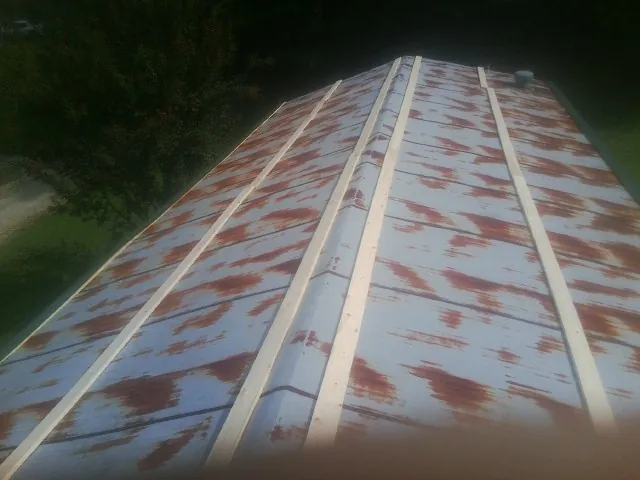 Rusted metal roof panels with new wood purlins before replacement — Storm Damage Roof Repair in Franklin Park by Roofing Brothers