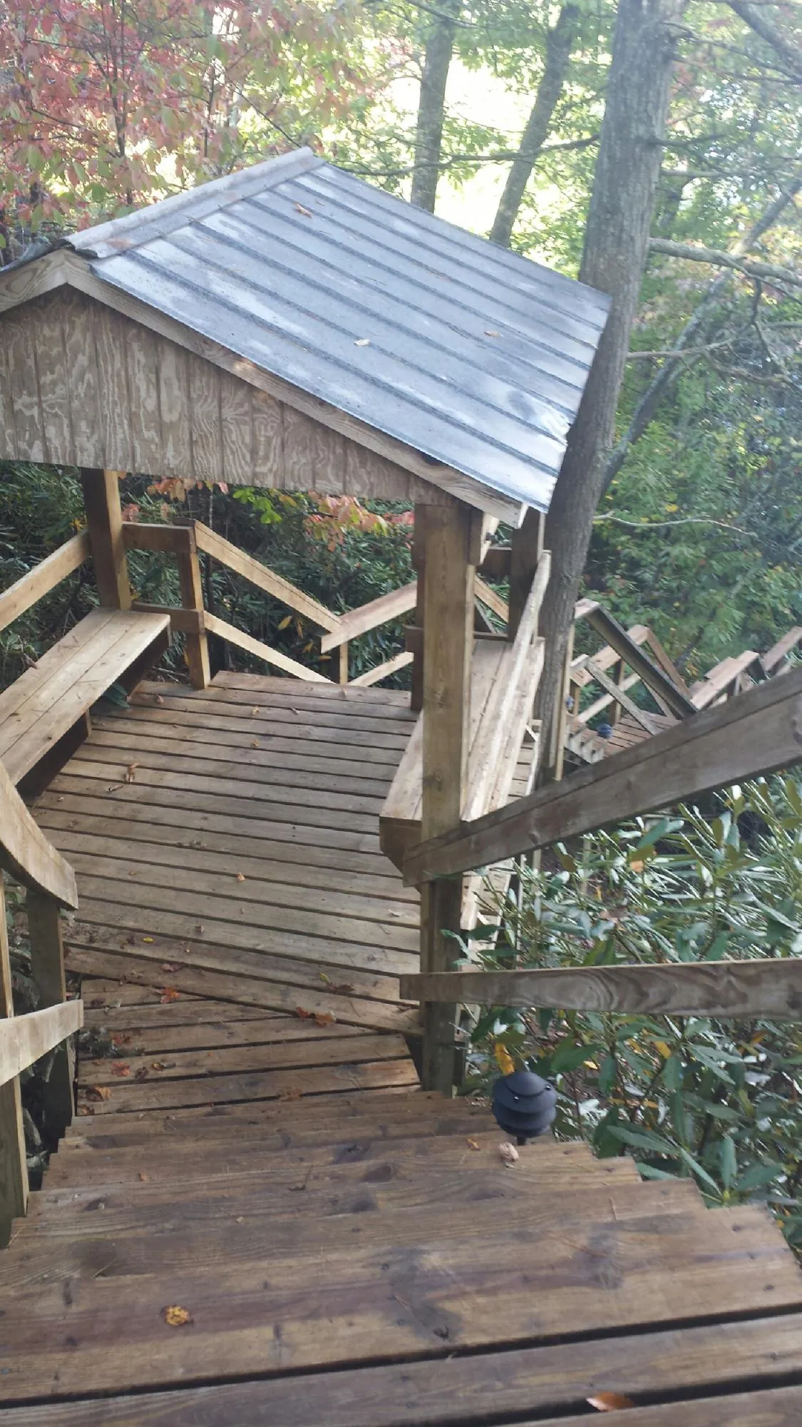 Metal roofed shelter over wooden steps on a wooded walkway — Skylight Repair & Installation work by our crew in Franklin Park